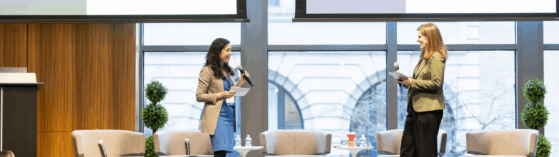 Two women stand on stage